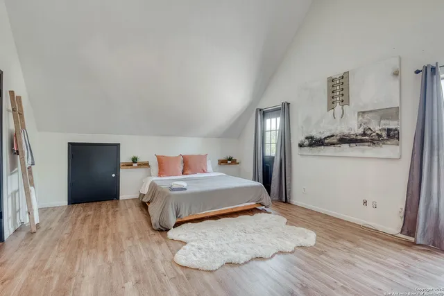 a bedroom with a bed and wooden floor