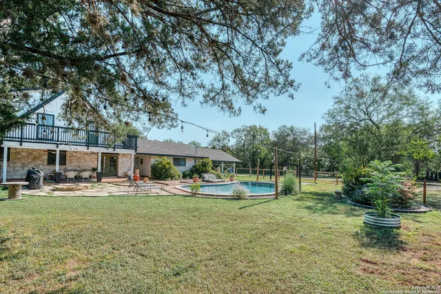 a front view of a house with garden and trees
