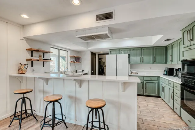 a kitchen with stainless steel appliances granite countertop a table and chairs in it