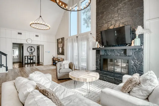 a living room with furniture a flat screen tv and a fireplace