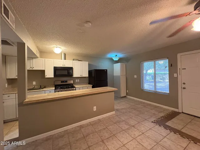a large kitchen with a large counter top appliances and cabinets
