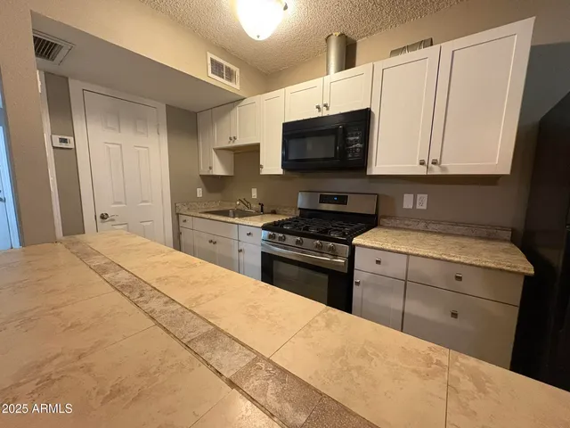 a kitchen with stainless steel appliances a stove microwave and sink