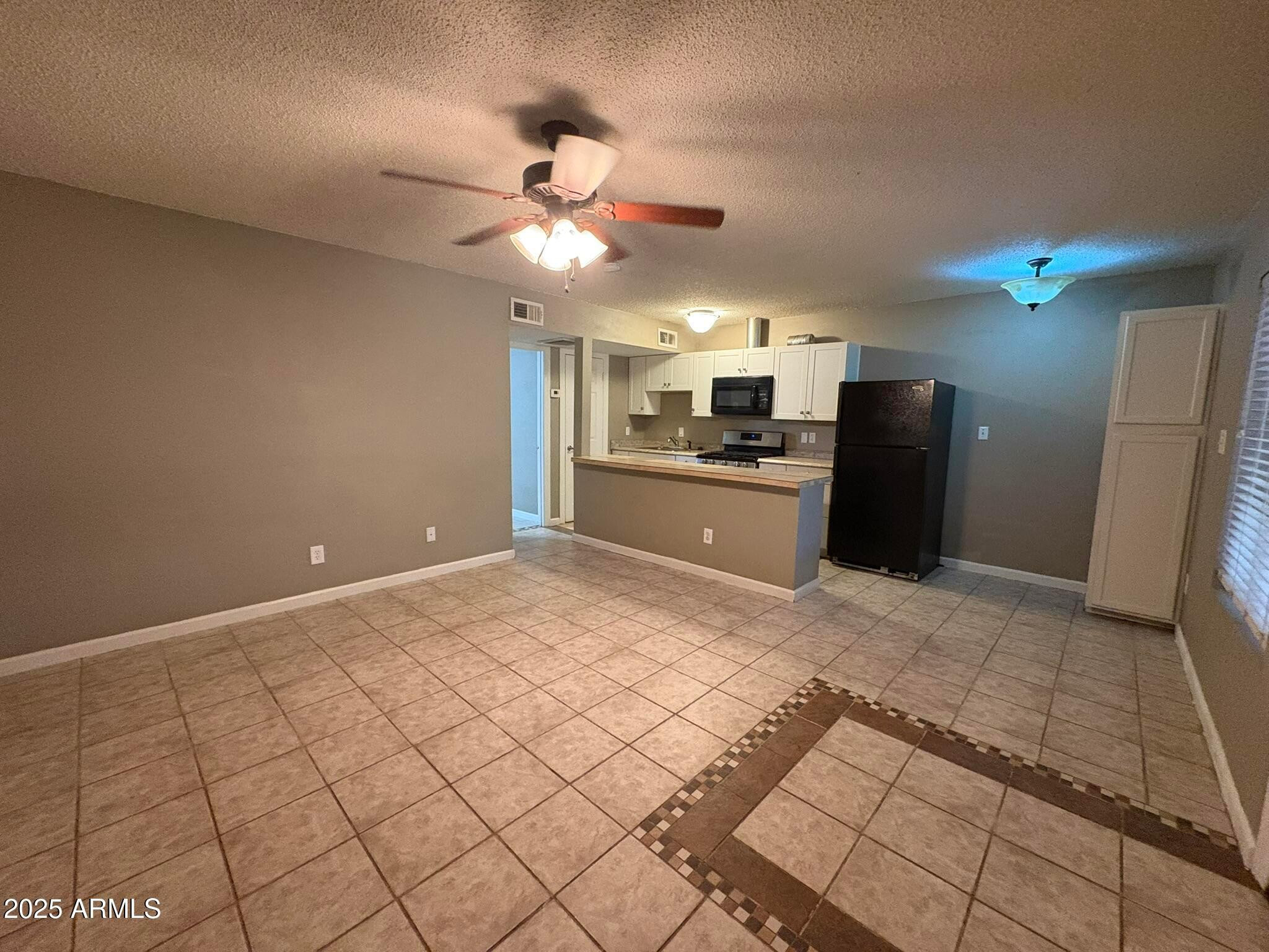2735 West Tuckey Lane, Unit 2 Phoenix, AZ 85017 - Photo 5 of 8 a view of a kitchen with a sink and a refrigerator