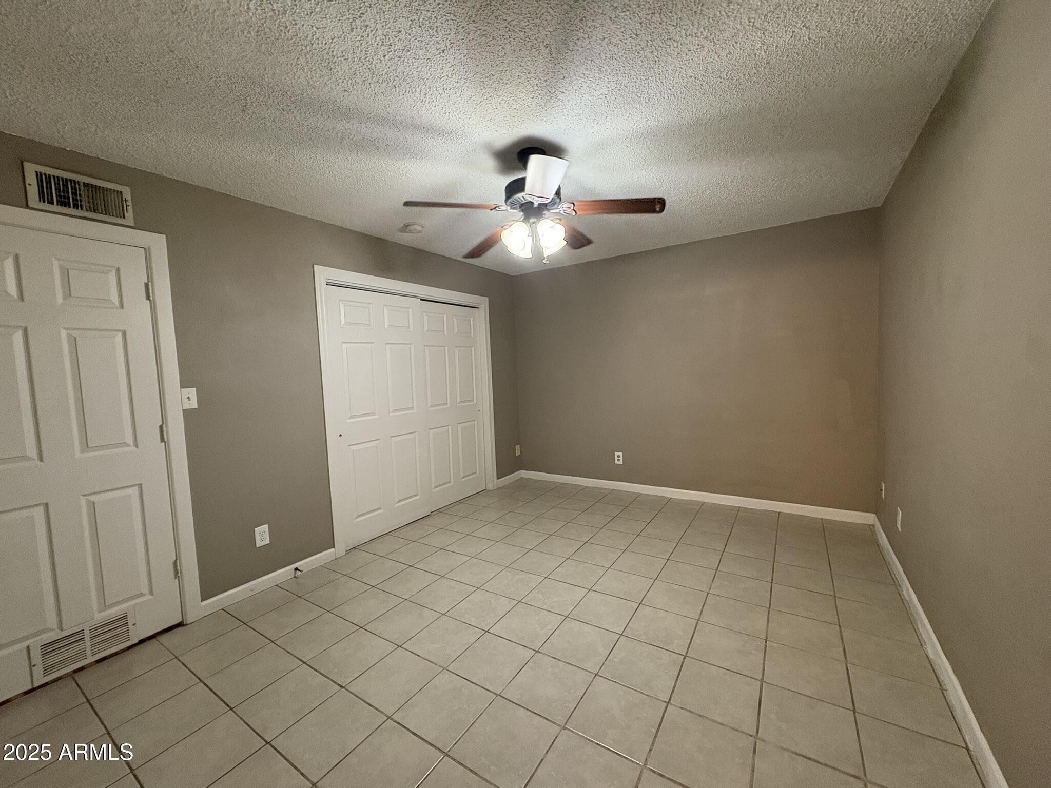 2735 West Tuckey Lane, Unit 2 Phoenix, AZ 85017 - Photo 7 of 8 a view of an empty room and chandelier fan