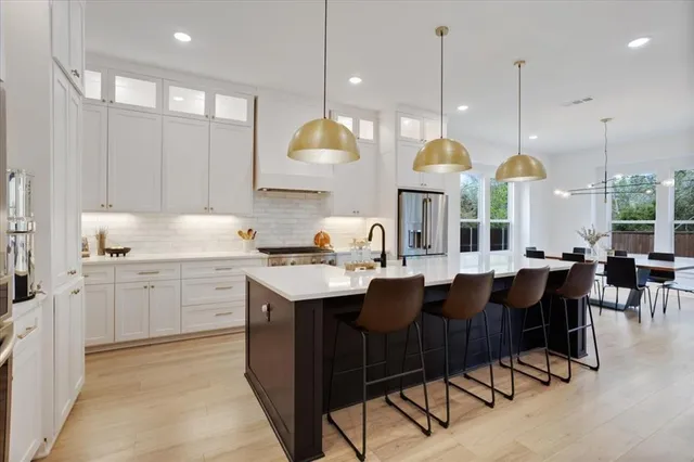 a kitchen with cabinets appliances and a dining table