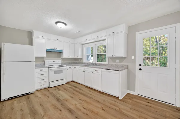 a kitchen with white cabinets and white appliances
