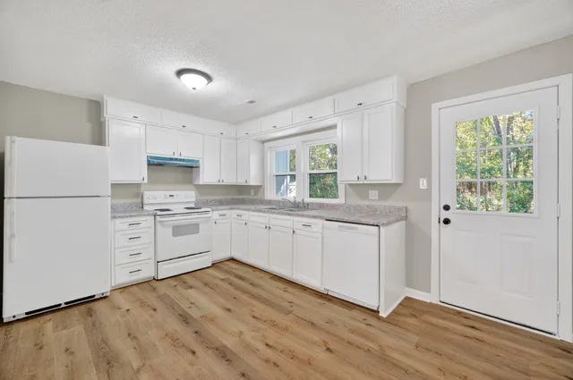 a kitchen with white cabinets and white appliances