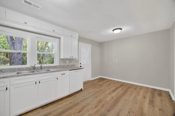 a room with a sink cabinets and a window