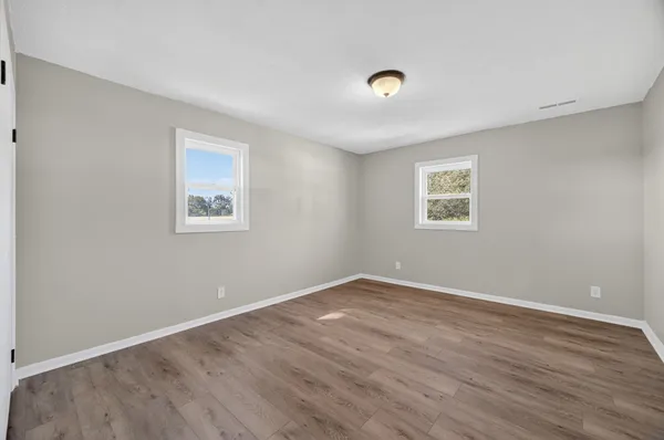 a view of a room with wooden floor and window