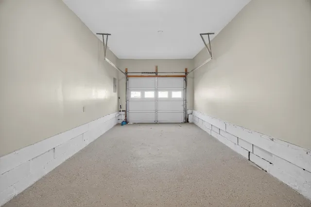 an empty room with windows and chandelier