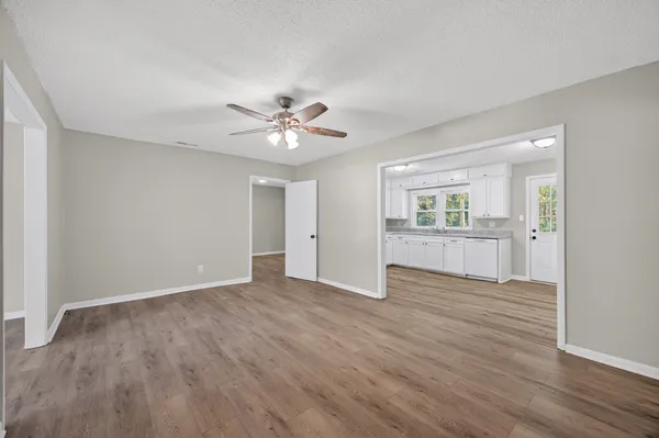 an empty room with wooden floor and windows