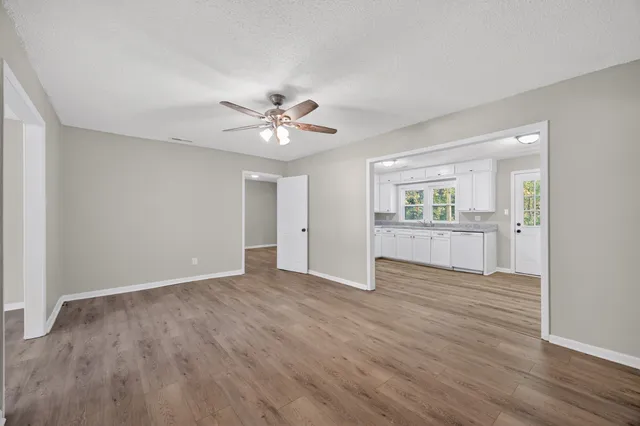 an empty room with wooden floor and windows