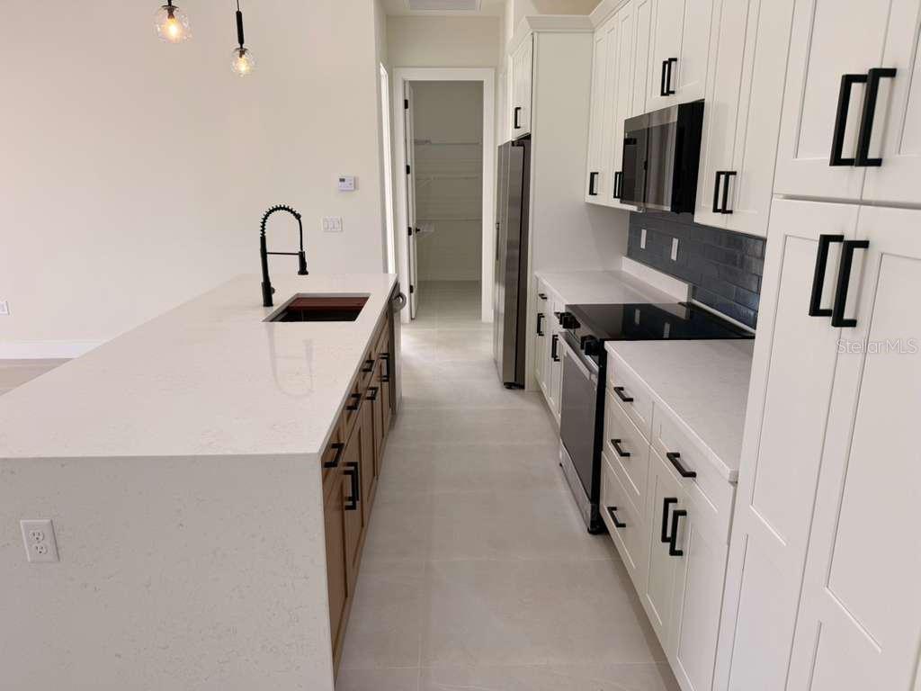 10426 Live Oak Road Port Charlotte, FL 33981 - Photo 20 of 53 a kitchen with stainless steel appliances a refrigerator sink and white cabinets