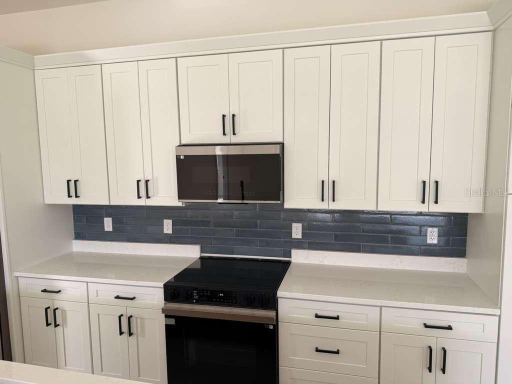 10426 Live Oak Road Port Charlotte, FL 33981 - Photo 21 of 53 a kitchen with granite countertop white cabinets and white appliances