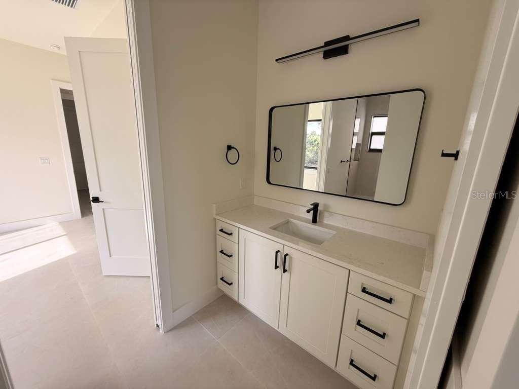 10426 Live Oak Road Port Charlotte, FL 33981 - Photo 41 of 53 a bathroom with a double vanity sink and mirror