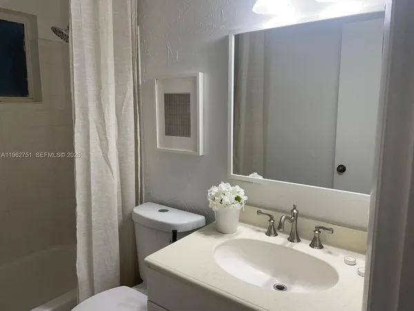a bathroom with a sink and mirror with toilet