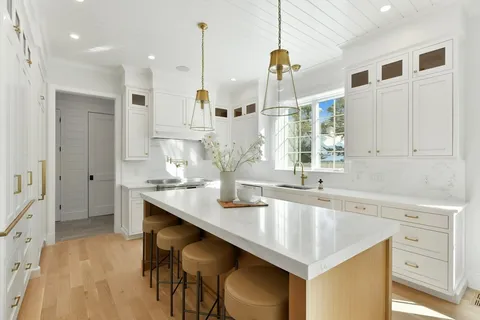 a kitchen with stainless steel appliances granite countertop a sink a stove and a wooden floors