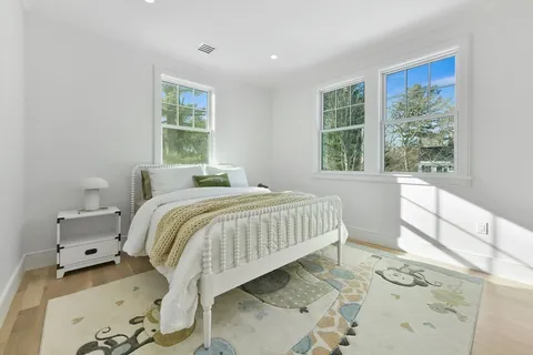 a bed sitting in a bedroom next to a window