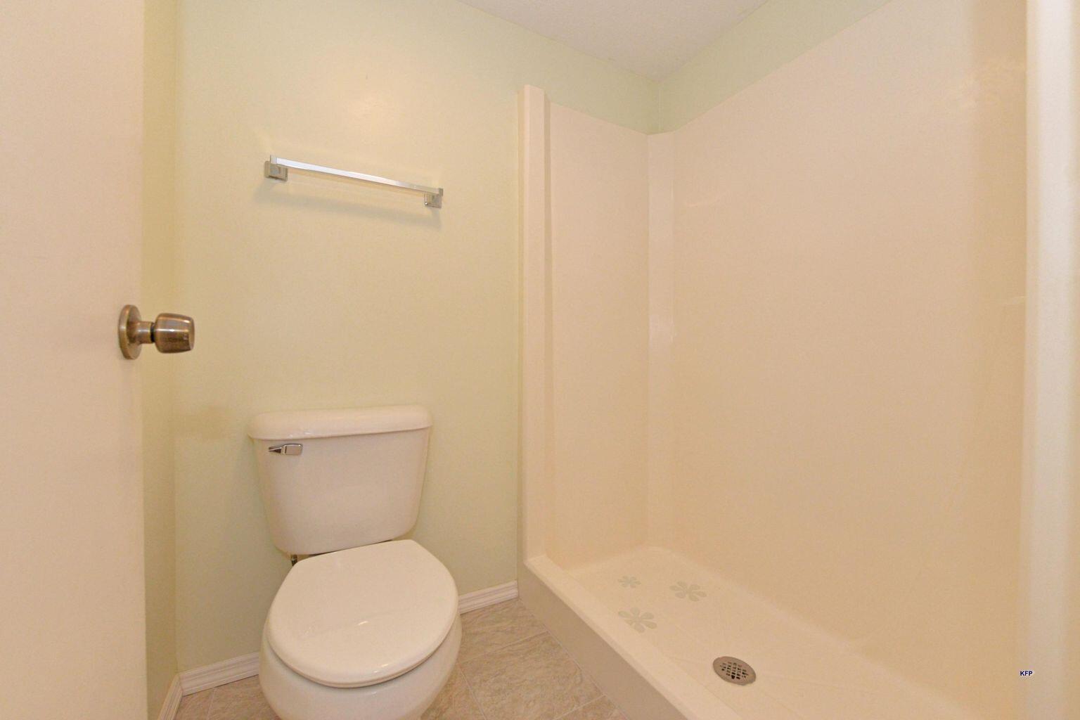 3254 Southeast Aster Lane, Unit 239 Stuart, FL 34994 - Photo 17 of 24 a white toilet sitting next to a shower