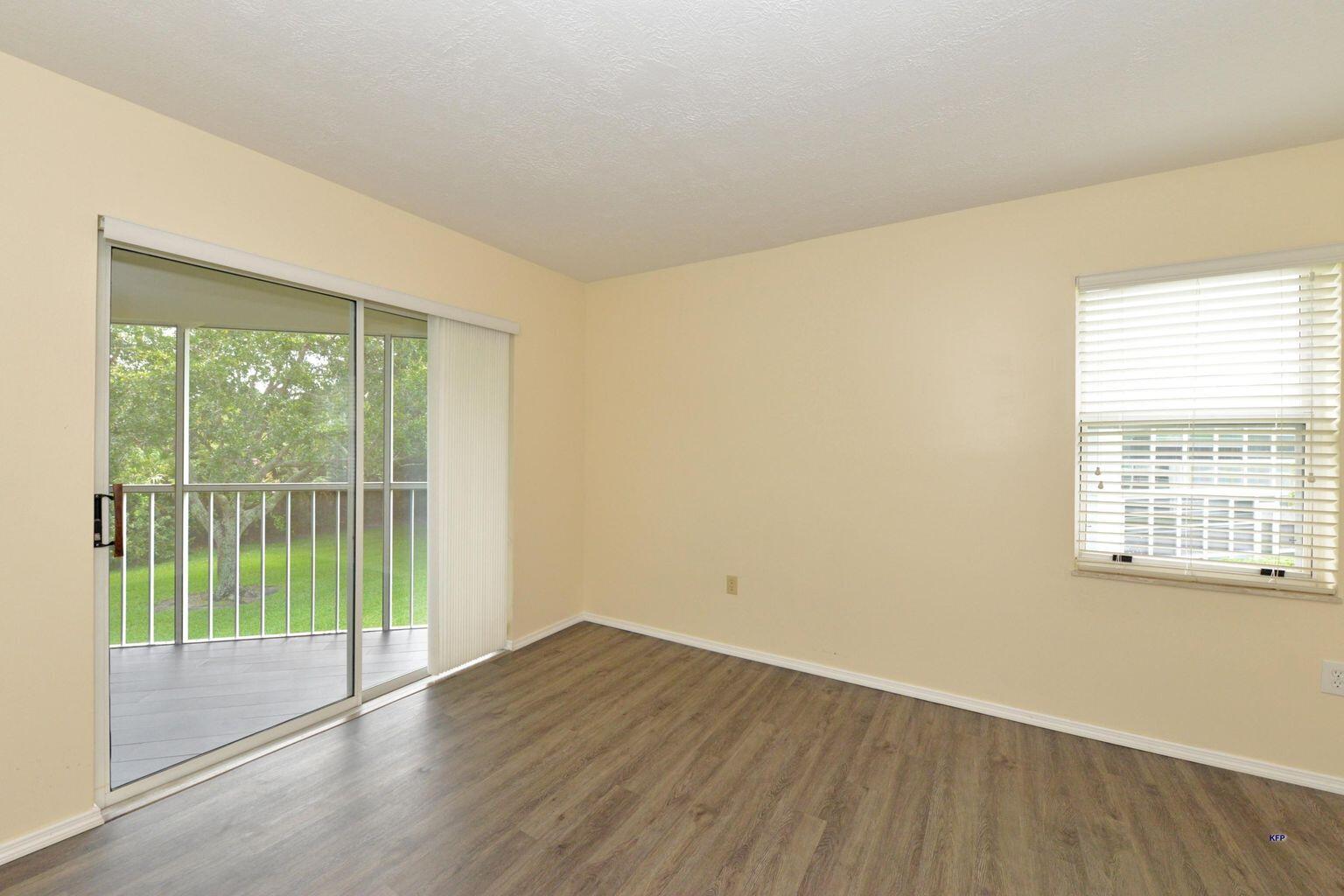 3254 Southeast Aster Lane, Unit 239 Stuart, FL 34994 - Photo 18 of 24 a view of an empty room with wooden floor and a window