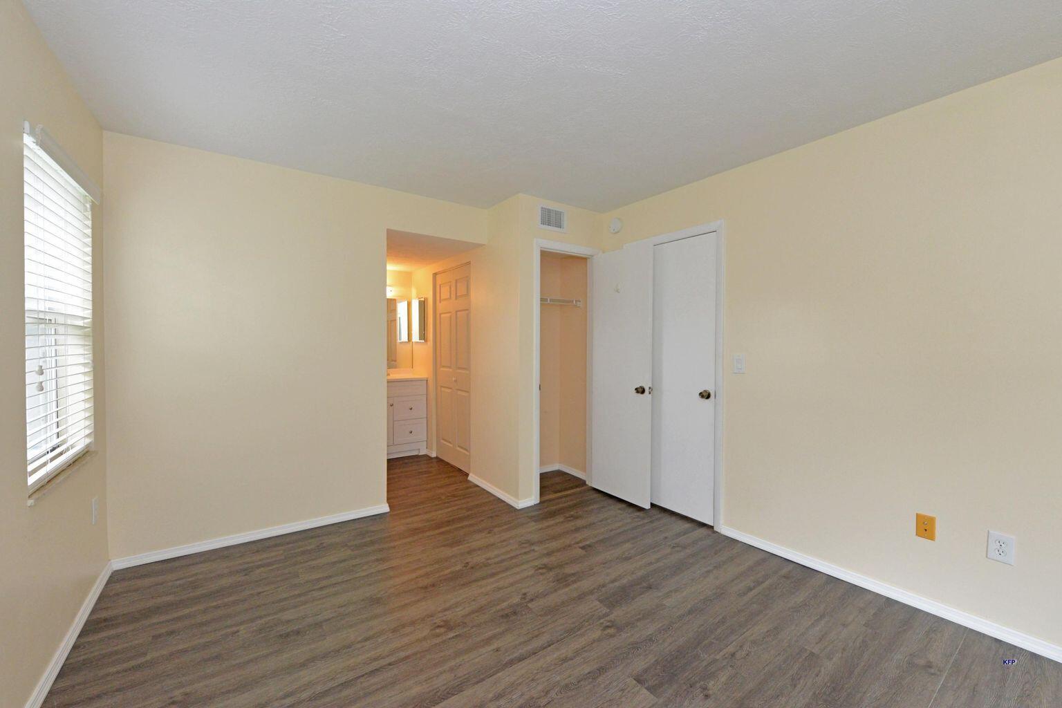 3254 Southeast Aster Lane, Unit 239 Stuart, FL 34994 - Photo 21 of 24 an empty room with wooden floor and windows