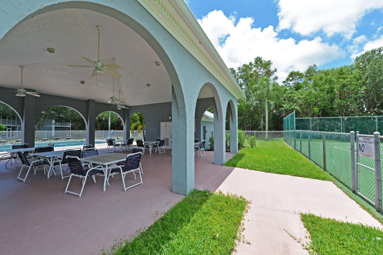 3254 Southeast Aster Lane, Unit 239 Stuart, FL 34994 - Photo 5 of 24 a view of a porch with furniture and garden