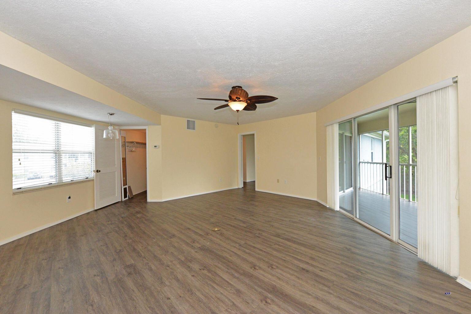 3254 Southeast Aster Lane, Unit 239 Stuart, FL 34994 - Photo 6 of 24 an empty room with wooden floor and windows