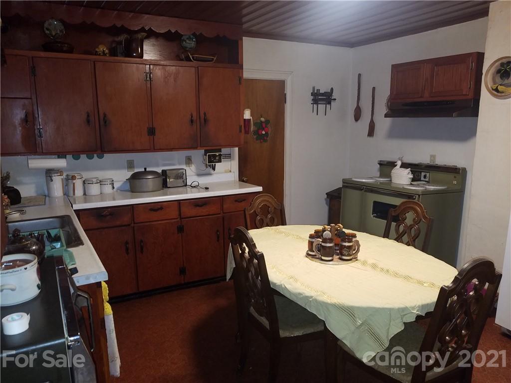 1118 Camp Branch Road Waynesville, NC 28786 - Photo 14 of 30 a kitchen with a sink a stove and chairs