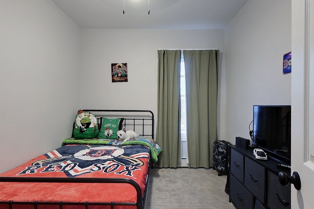 6 Kendall Street Methuen, MA 01844 - Photo 20 of 42 a bedroom with a bed and a flat tv screen on a dresser