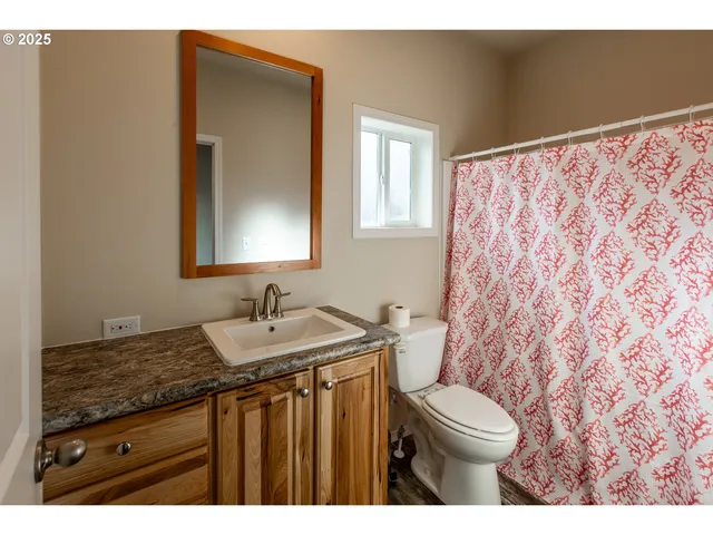a bathroom with a granite countertop sink a toilet and a mirror