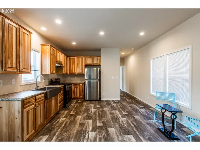 a open kitchen with kitchen island granite countertop wooden floors granite counter tops and a sink