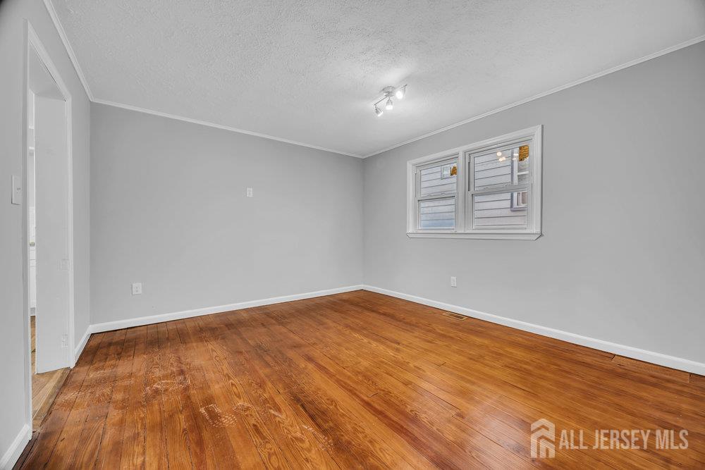 49 Comstock Street New Brunswick, NJ 08901 - Photo 11 of 20 an empty room with wooden floor and windows