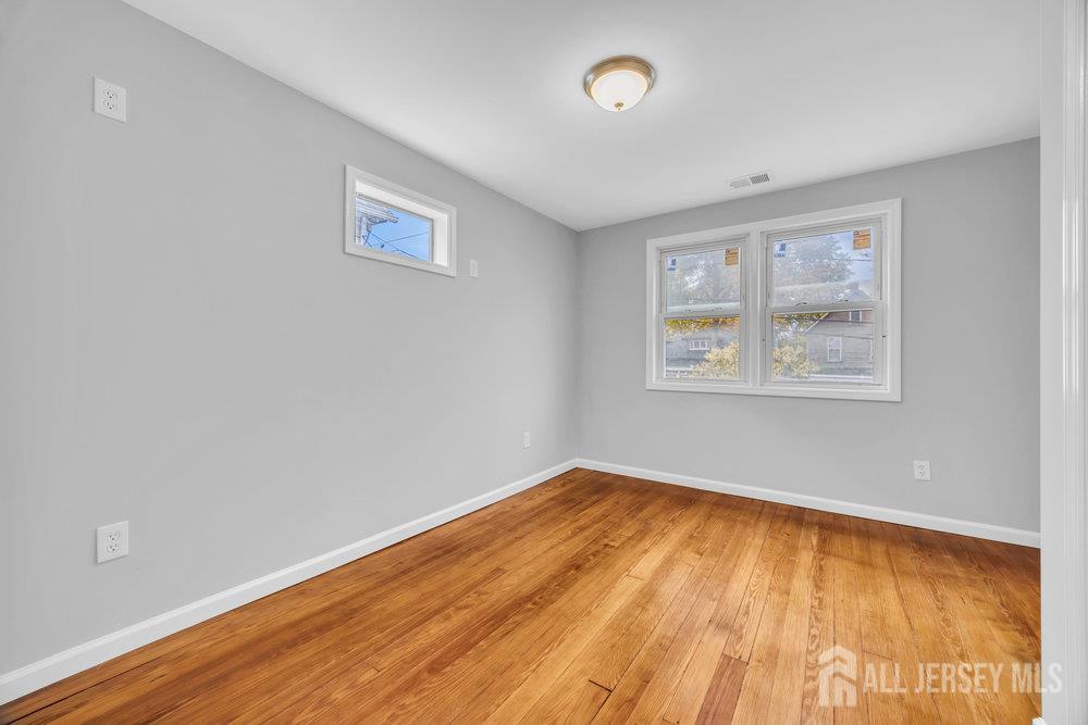 49 Comstock Street New Brunswick, NJ 08901 - Photo 15 of 20 an empty room with wooden floor and windows