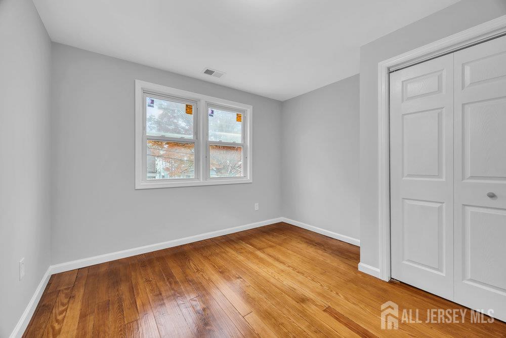 49 Comstock Street New Brunswick, NJ 08901 - Photo 16 of 20 an empty room with wooden floor and windows