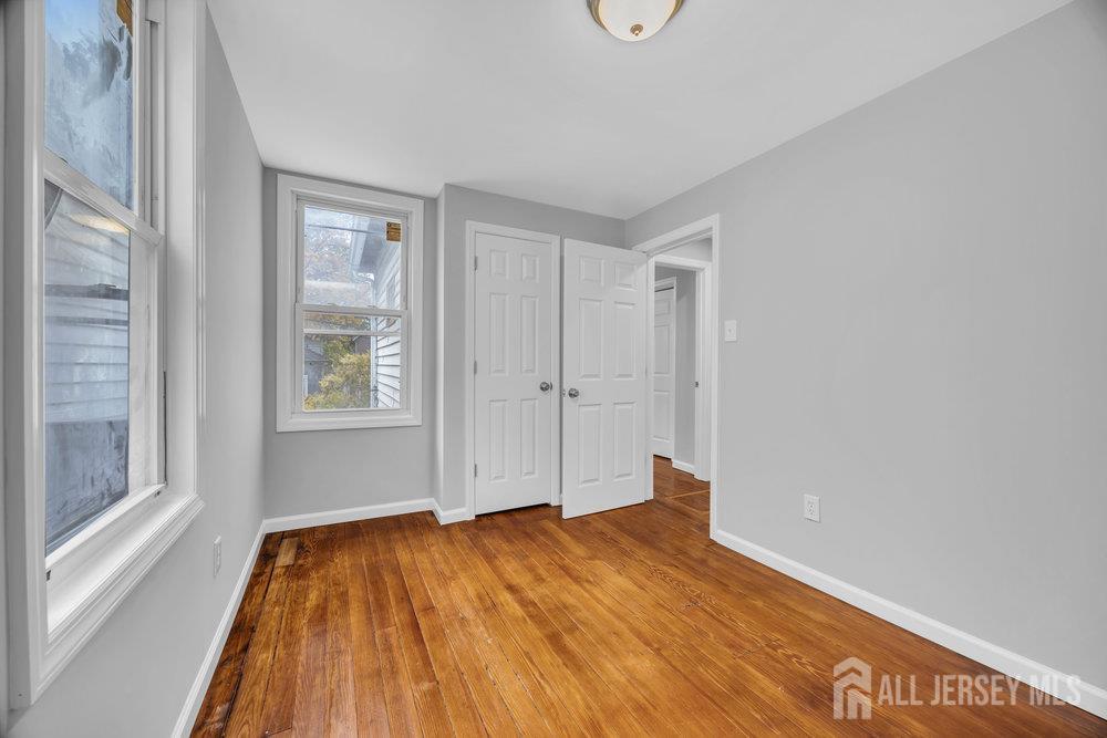 49 Comstock Street New Brunswick, NJ 08901 - Photo 17 of 20 a view of empty room with wooden floor and fan
