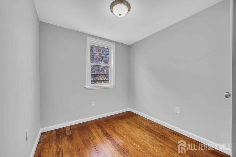 49 Comstock Street New Brunswick, NJ 08901 - Photo 18 of 20 a view of a room with wooden floor and white walls
