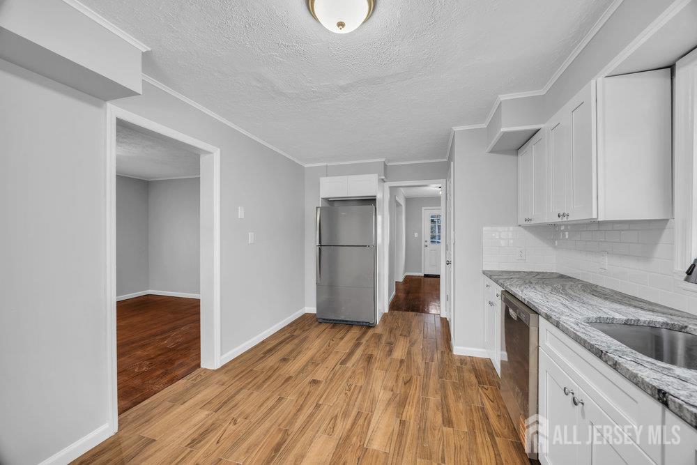 49 Comstock Street New Brunswick, NJ 08901 - Photo 7 of 20 a kitchen with wooden floors and wooden cabinets