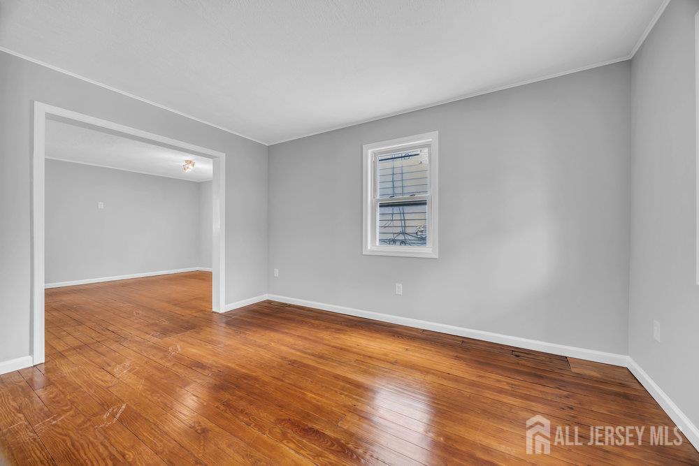 49 Comstock Street New Brunswick, NJ 08901 - Photo 8 of 20 a view of an empty room with wooden floor and a window