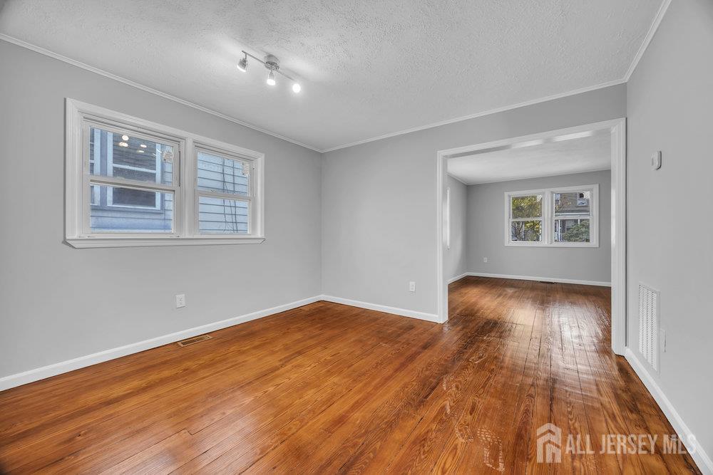 49 Comstock Street New Brunswick, NJ 08901 - Photo 9 of 20 a view of an empty room with wooden floor and a window