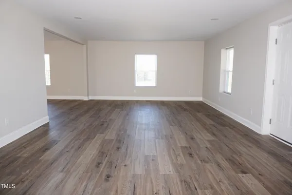 an empty room with wooden floor and window
