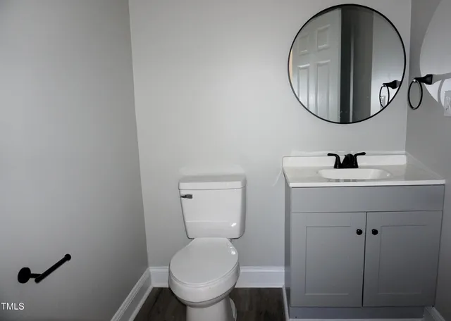 a bathroom with a toilet a sink and mirror