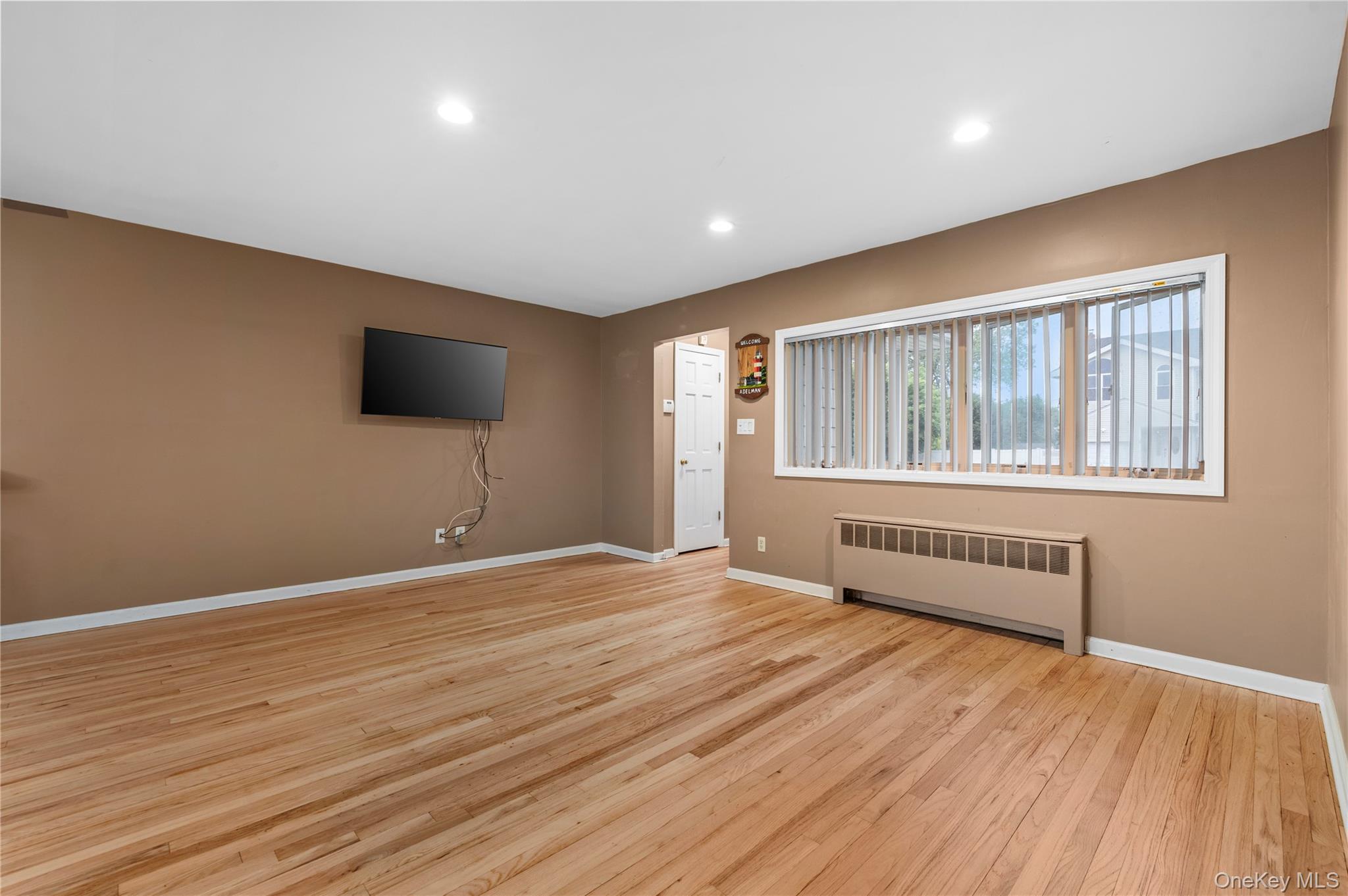 3 Cheshire Road Bethpage, NY 11714 - Photo 6 of 26 a view of an empty room with wooden floor and a window