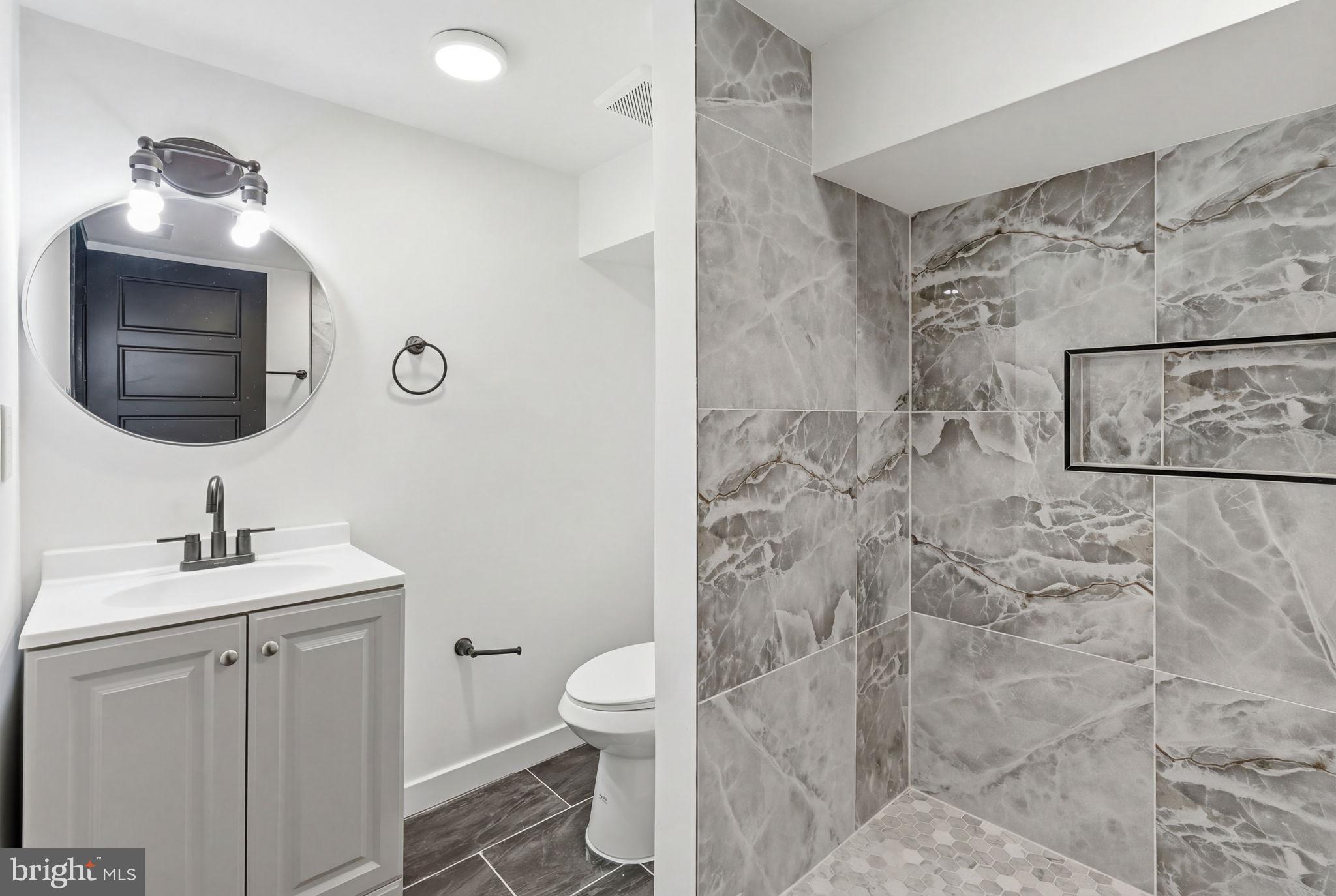 6508 Wheeler Street Philadelphia, PA 19142 - Photo 13 of 30 a bathroom with a sink toilet and mirror