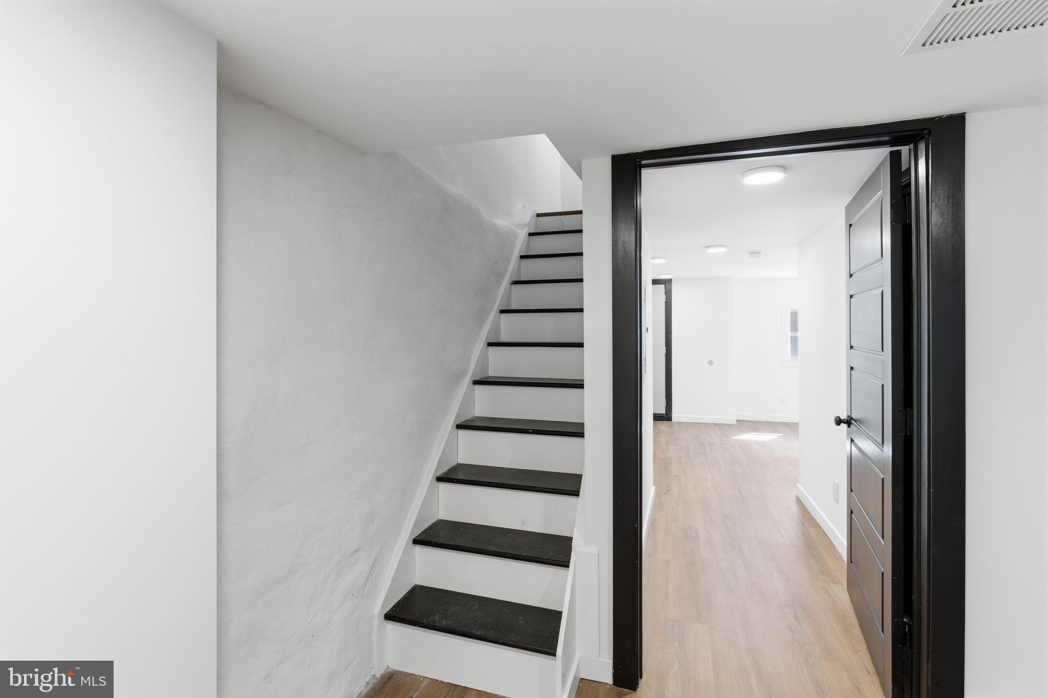 6508 Wheeler Street Philadelphia, PA 19142 - Photo 16 of 30 a view of a hallway with front door wooden floor and stairs