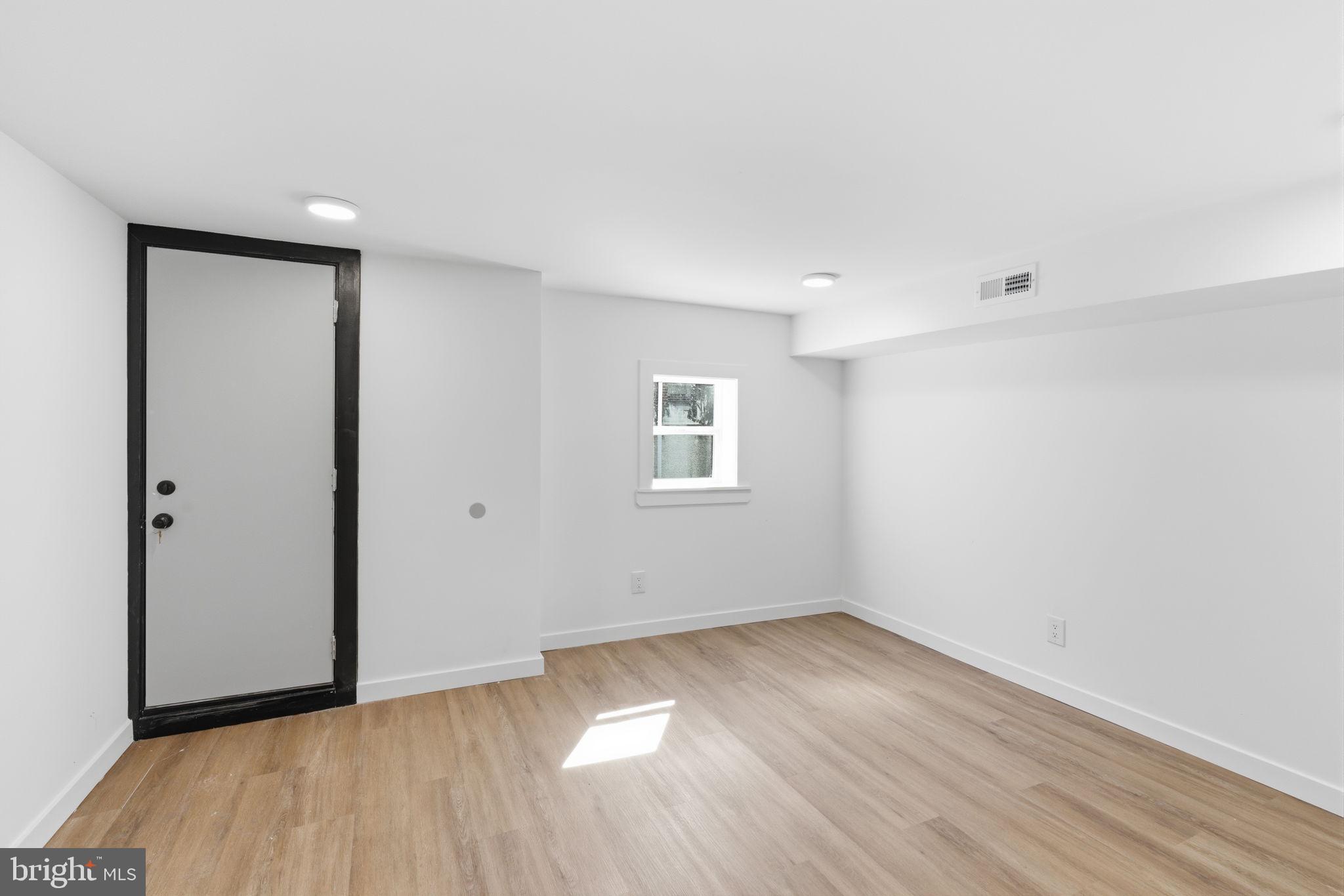 6508 Wheeler Street Philadelphia, PA 19142 - Photo 17 of 30 a view of an empty room with wooden floor and a window