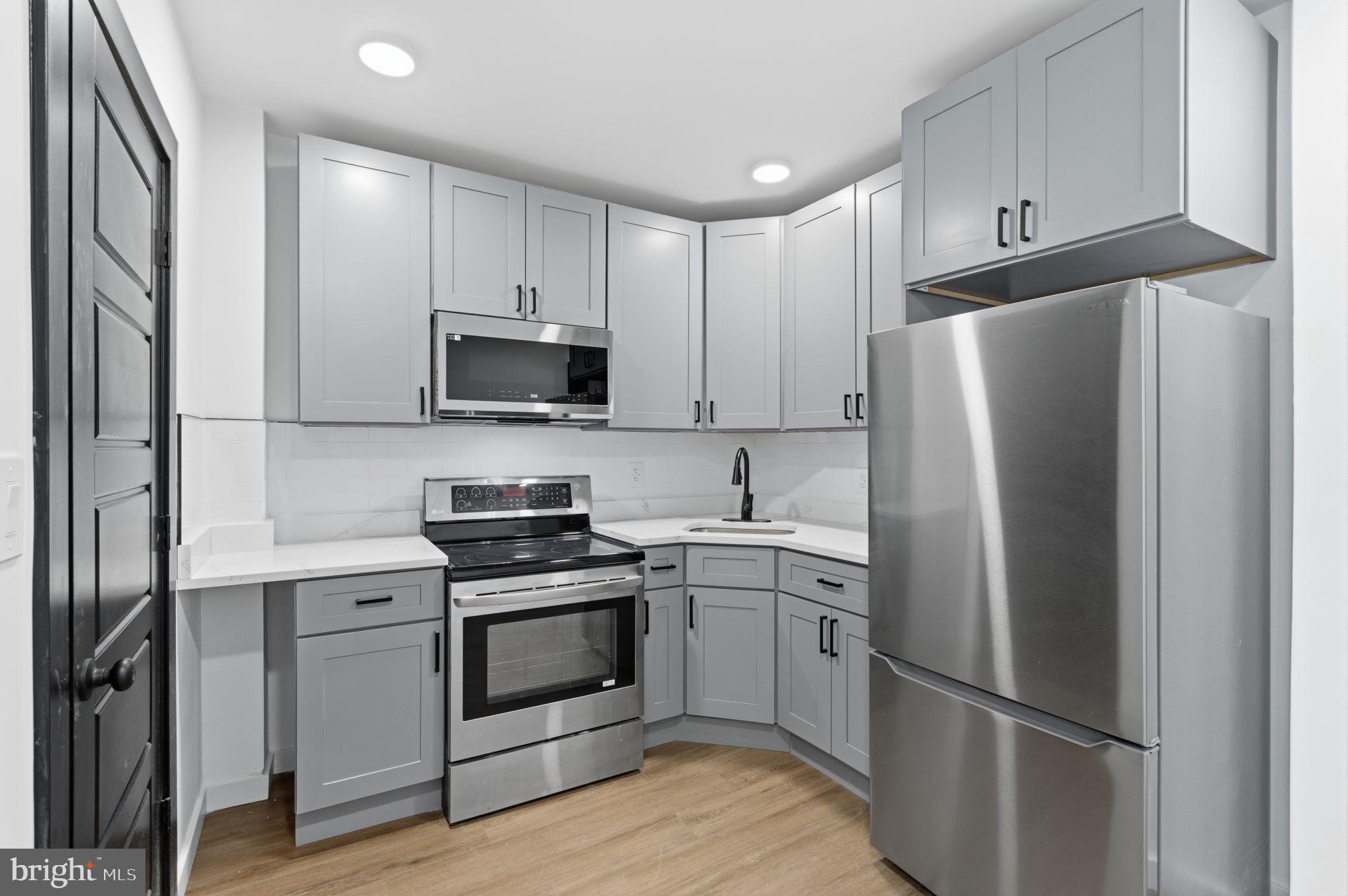 6508 Wheeler Street Philadelphia, PA 19142 - Photo 19 of 30 a kitchen with a stove sink and refrigerator