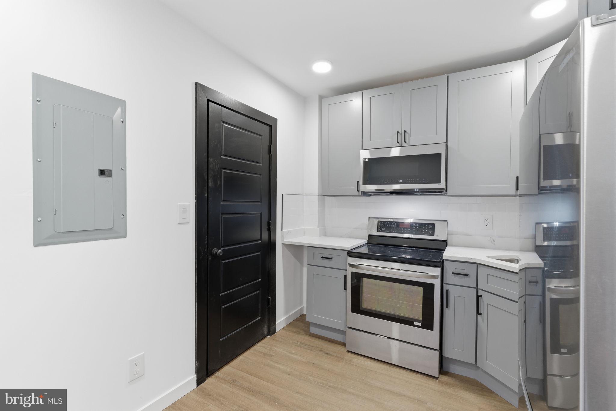 6508 Wheeler Street Philadelphia, PA 19142 - Photo 20 of 30 a kitchen with a stove and a microwave