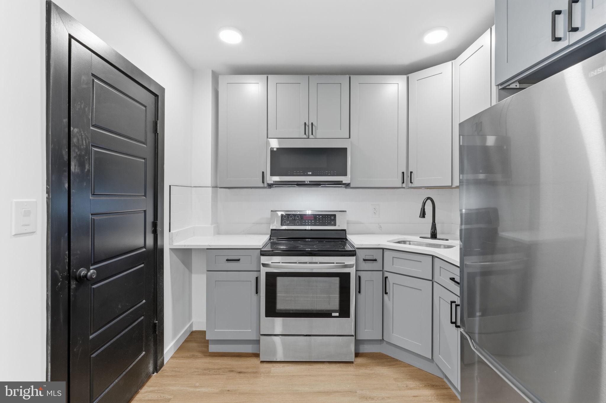 6508 Wheeler Street Philadelphia, PA 19142 - Photo 21 of 30 a kitchen with a stove sink and refrigerator