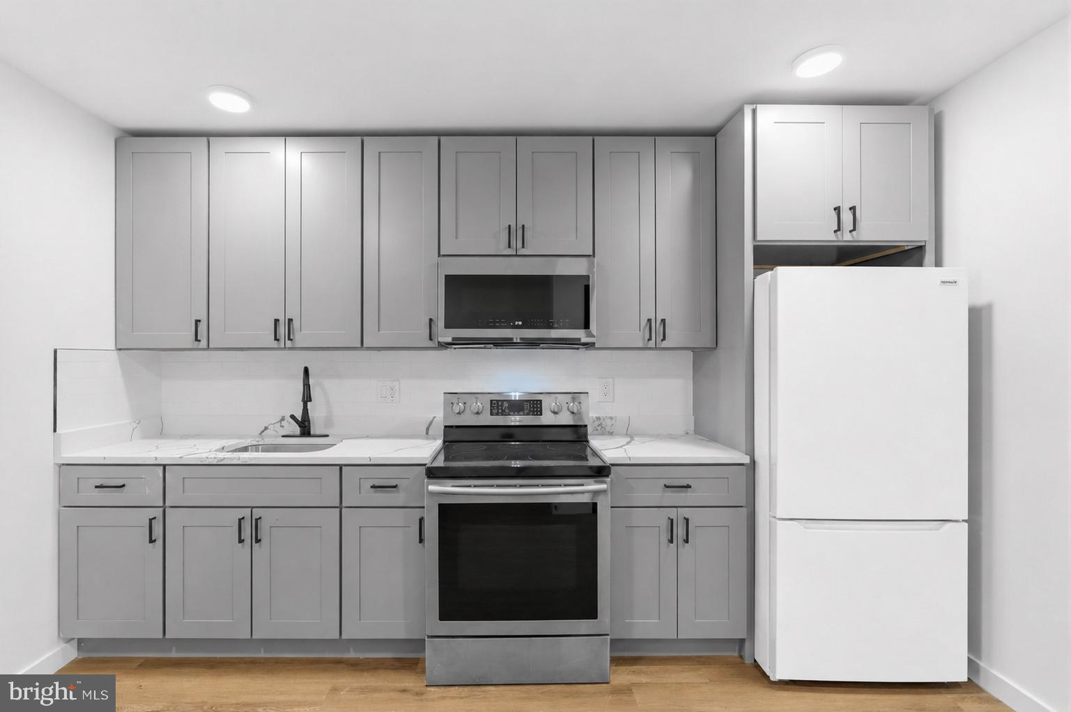 6508 Wheeler Street Philadelphia, PA 19142 - Photo 5 of 30 a kitchen with cabinets appliances and a sink