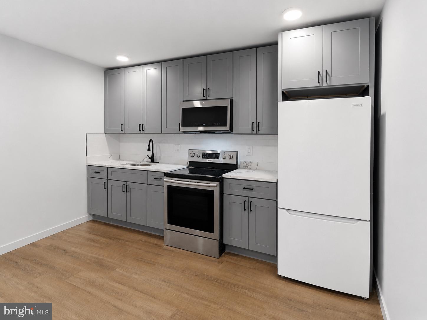 6508 Wheeler Street Philadelphia, PA 19142 - Photo 6 of 30 a kitchen with a refrigerator sink and microwave